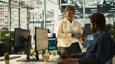 İşçilerin gelir, kazanç ve operasyonel verimlilik için kilit performans hedeflerini vurmasını sağlayan ofis müdürü. Kurumsal yönetim yönetim kurulu üyesi, işyerindeki çalışanla konuşuyor, kamera B