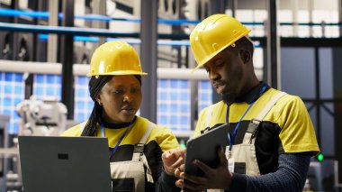 Güneş panelleri fabrika mühendisliği ekibi dişli arızalarını tahmin etmek için dizüstü bilgisayardaki performans verilerini analiz ediyor. Takım çalışması fotovoltaik, bakım prosedürlerini takip eden meslektaşları, kamera B