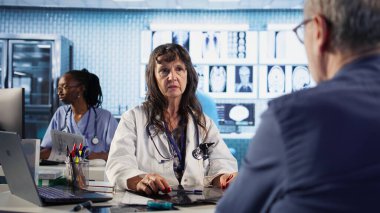 Kadın pratisyen doktor yaşlı adama kötü haber veriyor, röntgen sonuçlarını okuyor ve tehlikeli bir teşhis koyuyor. Endişeli yaşlı bir hasta için tarama yap. Kamera A.