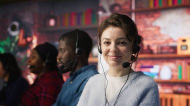 Dost canlısı müşteri destek çalışanları, müşterilerin ürün ve hizmetlerle ilgili sorularına cevap veriyor. Ofisteki neşeli çağrı merkezi temsilcisi müşterilere doğru ve tatmin edici bilgiler veriyor, kamera A