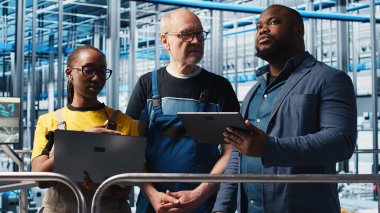 Akıllı fabrikanın yöneticisi, otomatik sistemleri test eden mühendislere talimatlar veriyor. Endüstri 4.0 Endüstriyel Santral Yöneticisi çalışanlarına dar boğazları ve kamera A 'yı teşhis etme görevi veriyor.