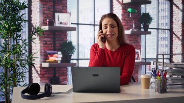 Modern bir çatı katında profesyonel bir kadın masasından bir telefon alıyor. Dizüstü bilgisayarıyla birden fazla iş yapıyor, iş stratejileri, serbest çalışma ve kariyer planlama konularını tartışıyor. Verimlilik. Kamera B.