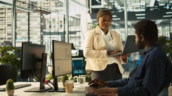 İşçilerin gelir, kazanç ve operasyonel verimlilik için kilit performans hedeflerini vurmasını sağlayan ofis müdürü. Kurumsal yönetim yönetim kurulu üyesi, işyerindeki çalışanla konuşuyor, kamera B