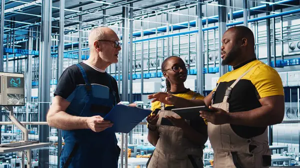 Akıllı fabrika mühendislik ekibi, tesisin zeminindeki robotik silah operasyonunu denetliyor. Endüstri 4.0 fabrika çalışma arkadaşları sistem performansını ve sorun çözme sorunlarını izliyorlar, kamera A