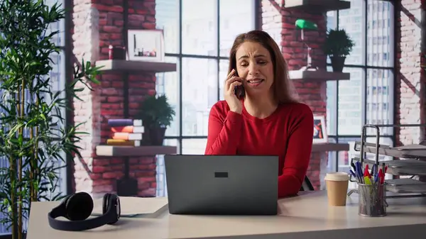 Modern bir çatı katında profesyonel bir kadın masasından bir telefon alıyor. Dizüstü bilgisayarıyla birden fazla iş yapıyor, iş stratejileri, serbest çalışma ve kariyer planlama konularını tartışıyor. Verimlilik. Kamera B.