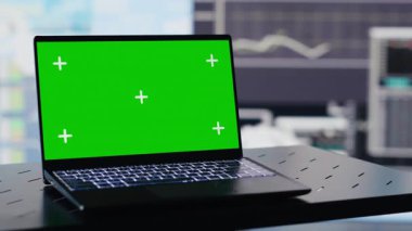 Boş iş sahasında yeşil ekranlı bir dizüstü bilgisayar görüntüsü, bilgi grafikleri ve karar verme ve strateji planlaması raporları var. Yapay zeka veri görselleştirmesi. Kamera A.