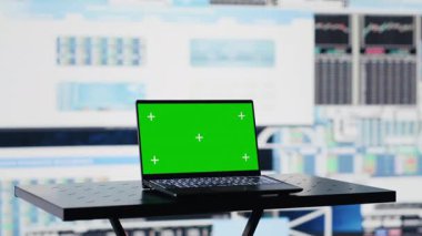 İşle ilgili bir alanda, dizüstü bilgisayar finansal verilerle strateji planlamasına yardımcı olmak için yeşil ekranı gösterir. Modern yapay zekayı ve büyüme verimliliğini temsil ediyor. Kamera A.