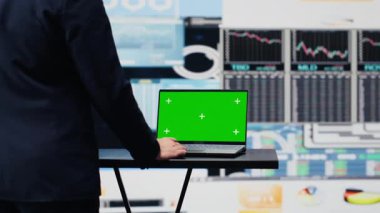 İşadamı, yıllık trendler için telefonda yeşil ekrana bakıyor, kurumsal başarı için bir strateji planlıyor. Aktiviteyi geliştirmek için raporlar ve infografik performans ölçümleri analiz ediliyor. Kamera A.