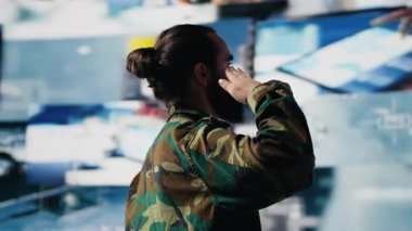 Gazi, bir kontrol merkezinde uydu verilerini inceledikten sonra savaş planlama taktikleri ve savaş alanı detayları üzerinde çalıştıktan sonra askeri selam veriyor. Ulusal güvenlik için yüksek teknoloji ordu ortamı. Kamera A.