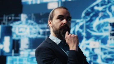 Genç işadamı torpido gözündeki yapay zeka sinir ağlarını inceleyerek, kodlama, analitik ve stratejik gelişim için yüksek teknolojili otomasyon araçları kullanıyor. Kamera A.