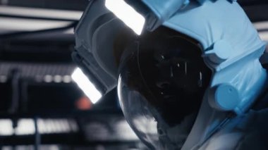 Astronot, acil durum uyarısını tetikledikten sonra yardım sinyali göndermek için bilek ekranına basıyor. Yaralı uzay istasyonu mürettebatı acil durum sırasında yer kontrolüyle temas kurmaya çalışıyor. Kamera B