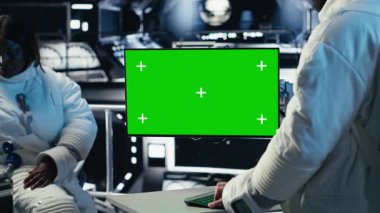 Astronot izleme sistemi tanıları yeşil ekran ekranında, uzay görevi sırasında iş arkadaşlarıyla konuşuyor. Takım çalışması kozmonotlar, insanoğlunun hayatta kalma seferi sırasında kroma anahtar monitörü kullanıyorlar, kamera B