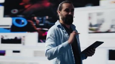 Erkek canlı sunucu izleyicilere markalaşma stratejisi ve sosyal eğilimler hakkında iletişim kuruyor, sunum sırasında mikrofon kullanarak iletişim ve küresel erişime yardımcı oluyor. Kamera A.