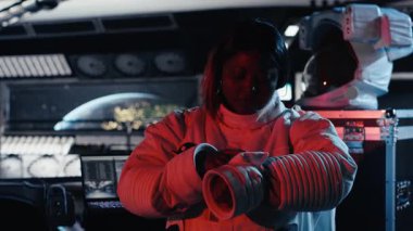 Dişi astronot, gözleri yabancı gemi ışığından koruyor. Uzay istasyonundaki dikkatli Afrikalı Amerikalı kadın dünya dışı varlıkla ilk teması bekliyor, kamera B