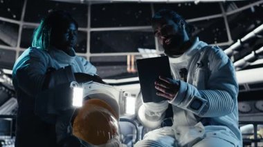 Astronot tabletteki analizleri inceliyor, uzay görevi sırasında meslektaşıyla konuşuyor. Takım halinde çalışan kozmonotlar, yıldızları ve asteroidleri takip ediyor.