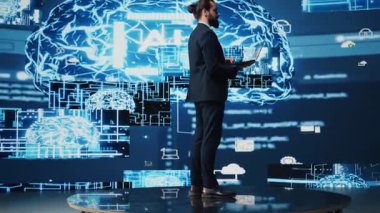 Erkek iş adamı yapay zeka stratejisi ve otomasyon araçları üzerine çalışıyor. Veri görselleştirmesi, sinirsel ağlar ve bulut hesaplamalarıyla çevrili olarak, akıllı teknolojiyi keşfeder. Kamera B.