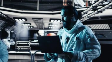 Astronot dizüstü bilgisayarında yıldız haritalarını inceliyor, uzay görevi sırasında meslektaşıyla tartışıyor. Takım çalışması kozmonotlar, insanoğlunun hayatta kalma seferi sırasında not defterindeki galaksi görselleştirmesine bakıyorlar, kamera B