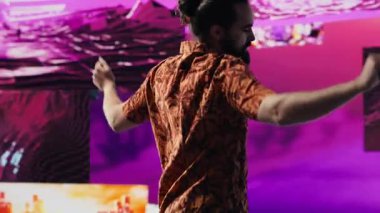 Elektronik ritimler ve sanatsal görsellerle kulüpte dans eden DJ etkileyicisi harika hareketler sergiliyor. Siber punk müzik kültürü ve yaratıcılığı kentsel dijital yaşam tarzını yakalar. Kamera A.