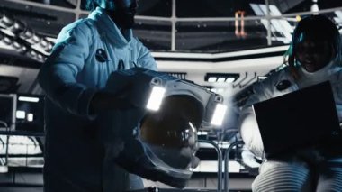 Uzay istasyonunun dışına çıkmadan önce laptopta veri analizi yapan astronot ekibi. Takım çalışması kozmonot gezegen B 'ye indikten sonra not defterine görev parametrelerini doğruladı