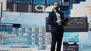 Sanal grafikler ve tahmin modelleriyle çevrili olan baş yönetici, iş büyümesini yönlendirmek için mali verileri ve görüşü kullanıyor. Performans sağlamak ve akıllıca kararlar vermek. Kamera B.