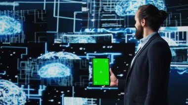 Sinirsel ağlar üzerinde çalışan genç bilişim uzmanı, tabletinde yapay zeka ile yapay ekran kullanıyor. Modern yapay zeka stratejisi ve yenilik için otomasyon kullanan bir adam. Kamera B.