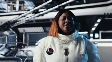 Uçuş sırasında toplanan araştırma verilerini sunan video çağrısında araştırmacıları selamlayan neşeli astronot. Uzay istasyonundaki arkadaş canlısı kadın Dünya ekibi B kamerasına deneyler sunuyor.