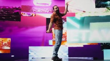 Parlayan neon bir atmosferde, genç kaygısız bir adam eğlenceli dans hareketleri ve yüksek enerjiyle gösteri yapıyor. Havalı DJ müzik eşliğinde dans ediyor, görsel sanat, teknoloji ve ses sergiliyor. Kamera B.