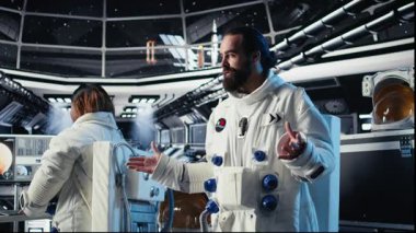 Astronot dalgaları, Dünya Komuta Merkezi ile video görüşmesi sırasında uzay gemisinde görev güncellemesini paylaşırken el ele veriyor. Kozmonot, yer merkezi ve kamera A arasındaki iletişim sırasında araştırmacıları selamladı