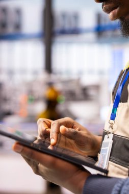 Endüstriyel otomasyon uzmanı akıllı fabrika operasyonlarını düzene sokmak için dijital araçlar kullanır. Tablet üzerindeki mühendislik analiz sistemi verilerinin kapatılması, üretim hattındaki robotik otomasyonun ince ayarı.