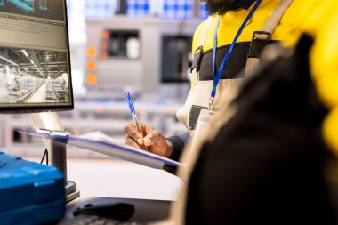 Endüstriyel otomasyon sistemini kontrol eden profesyonel mühendise yakın çekim. Akıllı üretim fabrikası dijital teknoloji, robotik silahlar ve otomatikleştirilmiş üretim bantları entegre eder