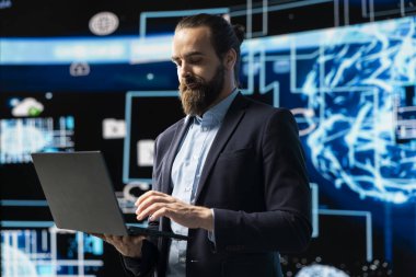 Girişimci gösterge panelindeki yapay zeka sistemini incelemek için dizüstü bilgisayar kullanır, kodlama, analitik ve makine öğrenimi için yüksek teknoloji veri görselleştirmesi kullanır. Stratejik gelişim.