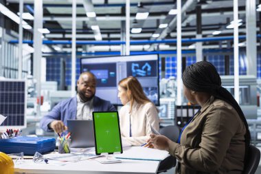Güneş panelleri fabrika yöneticileri ekibi enerji üretimini ve verimliliğini izlemek için model cihazı kullanıyor. İzole edilmiş ekran tabletinde fotovoltaik fabrika izleme sistemi performansı yatırımcıları