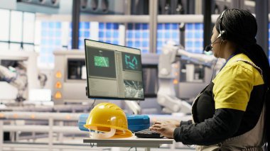 Otomatik üretim fabrikası uzmanı canlı üretim verilerini analiz ediyor, kulaklık mikrofonunu kullanarak mühendislere robotik silahlar, taşıma bantları ve fotovoltaik sistemler, kamera B hakkında bilgi aktarıyor.