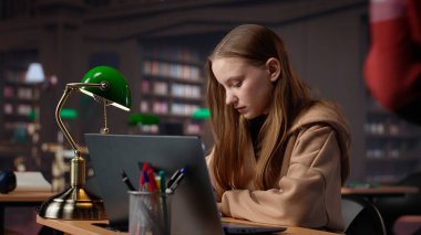 Bayan öğrenci, akademi veritabanı ve el yazısıyla yazılmış notlarla ilgili araştırmaları birleştirerek üniversite dergileri için son hazırlıklarını yapıyor. Eğitimli kız ders çalışıyor. Kamera A.