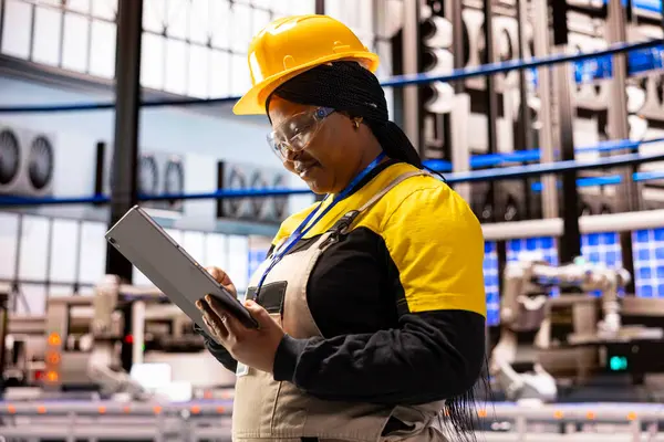 Endüstriyel tesislerdeki ekipmanları izlemek ve kontrol etmek için tablet kullanan profesyonel kadın mühendis. İnovasyon, kalite kontrolü ve iklim dostu teknolojiye odaklanıyor..