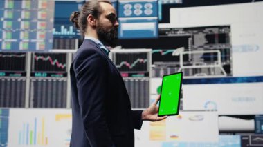 Girişimci, kurumsal performansı ve gelecek başarı planını optimize etmek için uzay ekranı ve gösterge panelleri, finans trendleri ve KPI metrikleri ile tableti elinde tutuyor. Büyüme planı. Kamera B.