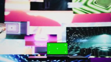 Boş bir alan ve sanatsal ışıkların yanında yeşil ekran maketini gösteren bir dizüstü bilgisayar, gece ortamı ve müzik kültürü için ses manzarası yaratıyor. Görsel sanat titreşimleri yaymak ve yaratıcılık. Kamera B.