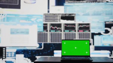 İşle ilgili bir alanda, dizüstü bilgisayar finansal verilerle strateji planlamasına yardımcı olmak için yeşil ekranı gösterir. Modern yapay zekayı ve büyüme verimliliğini temsil ediyor. Kamera B.