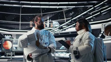 Kozmonotlar iş arkadaşlarıyla yumruk tokuşturup, insanoğlunun hayatta kalma seferi sırasında yıldızgemisini gezegene inmeye bırakıyorlar. Astronot miğfer takıyor, uzay gemisinden çıkıp gezegene yerleşiyor, kamera A