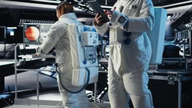 Astronot uzay istasyonu dışında planlanan operasyonlara katılmadan önce güvenlik kontrolü yapıyor. Kozmonot, Mars 'a indikten sonra ayrılmaya hazırlanan cihazın dişli kontrollerini kontrol ediyor. Kamera A.