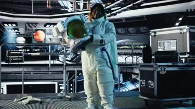 Yabancı gezegendeki yüzey görevini tamamladıktan sonra uzay istasyonunda miğfer tutan mutlu astronot portresi. Neşeli kozmonot Dünya 'ya dönmeye hazırlanıyor. Kamera A.