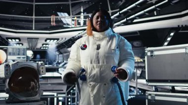 Uçuş sırasında toplanan araştırma verilerini sunan video çağrısında araştırmacıları selamlayan neşeli astronot. Uzay istasyonundaki dost canlısı kadın, Dünya ekibi ve kamera A 'ya deneyler sunuyor.