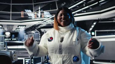 Neşeli astronot dalgaları Dünya Komuta Merkezi ile video görüşmesi sırasında el sallıyor, uzay deneylerinin sonuçlarını belgeliyor. Kozmonot yer merkezini selamlıyor, araştırma gözlemlerini paylaşıyor, kamera A