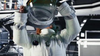 Kafasında miğfer olan neşeli astronot uzay aracı kullanarak uzayda insan genleşmesi yapıyor. Yıldız gemisindeki mutlu Afrikalı Amerikalı kadın, insanlığın uzun vadede hayatta kalmasını destekleyen keşif gezisine hazırlanıyor.