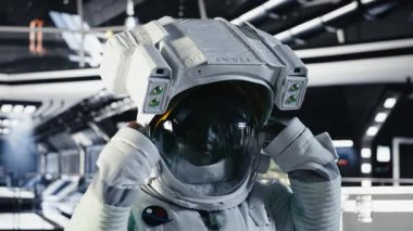 Yörünge istasyonu dışında planlanan operasyonlara çıkmadan önce miğfer tutan mutlu astronot portresi. Uzay aracında gülümseyen kozmonot uzak gezegen yüzeyine yaklaşıyor, kamera B