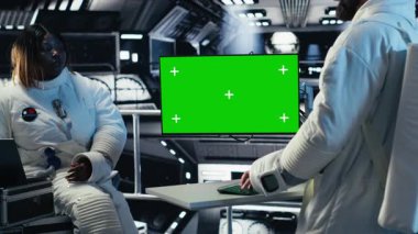 Gelişmiş teknoloji uzay aracındaki astronotlar rutin görev kontrolü sırasında uçuş günlüğünü güncelleyen yeşil ekran monitörü kullanıyorlar. Yörünge istasyonu personeli sistem tanılarını görüntüleme ekranında inceliyor