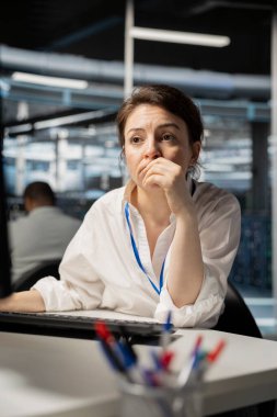 Veri merkezindeki bilgisayar bilimci bilgisayardaki tanısal yazıları inceliyor, ekipmanları inceliyor. Ana bilgisayarların performans parametrelerini değerlendirmek için PC kullanan sunucu odası bilişim uzmanı, sistem istikrarını koruyor