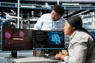 Sunucu merkezindeki bilgisayar personeli sunucuları hackerlardan korumaya çalışıyor. Yapay zeka veri merkezi siber güvenlik bölümü meslektaşları güvenlik ihlali sırasında platformları koruyor