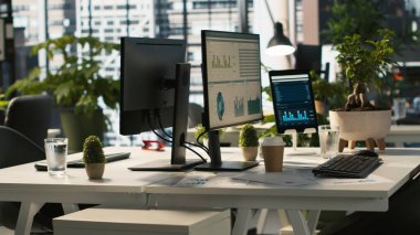 İş yerindeki monitörlerde iş grafikleri ve performans ölçümleri, el kamerası görüntüleri. Parlak kurumsal ortamda ofis masası kurulumu. Veri analizlerini gösteren monitörler, çekimler...