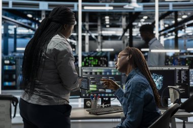 Veri merkezi ekibi, ekipman performansını optimize etmek için yapay zeka görselleştirme aracını kullanarak birlikte çalışıyor. Sunucu çiftliği çalışanları, yapay zeka analiz yazılımı kullanarak beyin fırtınası yapıyorlar.